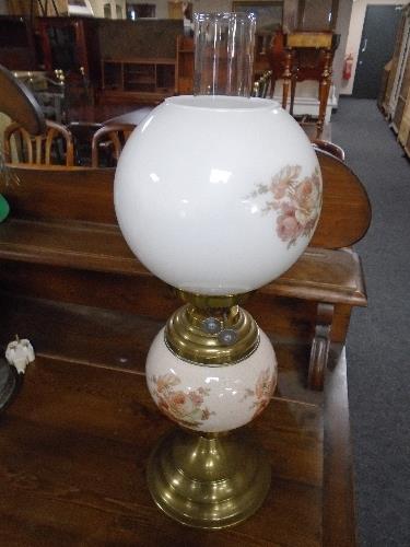 An early 20th century ceramic and brass oil lamp with white glass shade