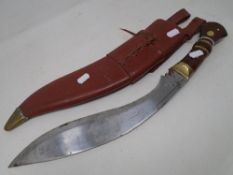A reproduction Kukri knife in leather sheath