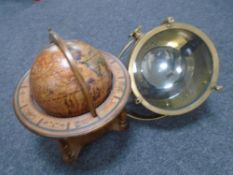 A contemporary brass cased spotlight together with a wooden globe on stand.