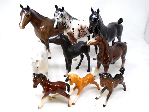 A tray containing nine ceramic horses including Beswick examples.