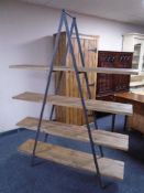 A contemporary wrought iron and pine shelving unit.