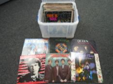 A plastic storage box containing vinyl records including The Beatles, Elton John, Bruce Springsteen,