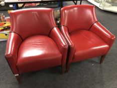 A pair of contemporary armchairs upholstered in red leather.