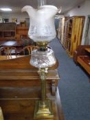 A Victorian glass oil lamp on Corinthian column base with clear glass reservoir and opaque glass