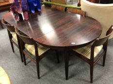 A mid century Danish rosewood circular extending dining table with two leaves,