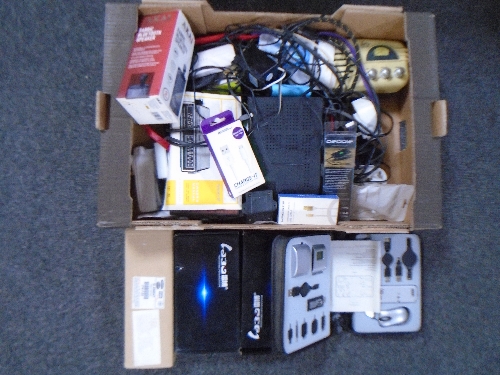 Two boxes containing clock radios, charging cables, Freeview box, professional car speakers,