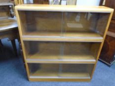 A mid-20th century teak three tier stacking bookcase with sliding glass doors.