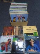 A box containing vinyl records including Elvis, world music, easy listening etc.