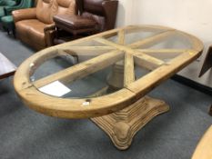 A rustic pine oval pedestal dining table with eight glass inset panels,