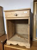 An antique pine bedside stand fitted with a drawer.