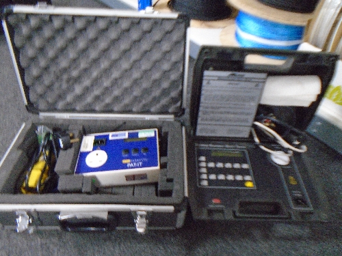 A cased Metro safety tester together with a further aluminium case containing a Tele PAT-IT tester.