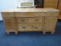 A 19th century pine serpentine fronted farmhouse sideboard.