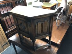 An Old Charm furniture carved oak linen fold cabinet on raised legs.