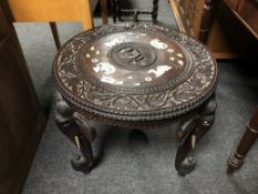 A 19th century heavily carved Indian occasional table on elephant trunk legs, height 103 cm,