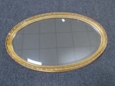 An oval framed bevelled mirror
