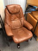 A Scandinavian brown buttoned leather swivel armchair