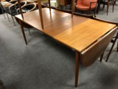 A mid century Danish teak flap sided dining table fitted two leaves