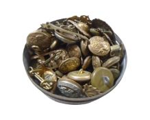 A tin containing a collection of military buttons and badges.