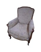 A French carved walnut framed armchair in floral fabric