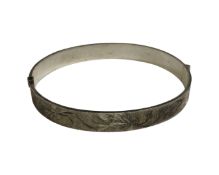 A silver bangle with textured sides and oversized hallmark, Bracelon Ltd, Birmingham 1977, 17.