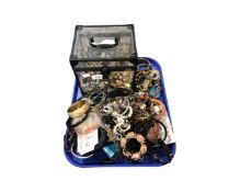 A Perspex jewellery box containing a large quantity of assorted costume jewellery.