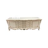 A cream and gilt shaped fronted double door buffet sideboard fitted with four central drawers width