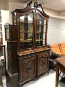 A 19th century French Louis XV style double door display cabinet with carved mouldings,