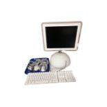 A 2003 Apple iMac computer with keyboard, speakers and mouse.