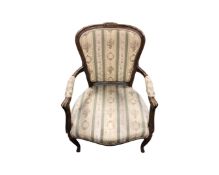 A carved beech framed salon armchair in striped fabric