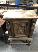 An early 20th century carved oak cabinet,