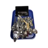 A tray containing a cased drawing set, assorted plated and stainless steel cutlery.