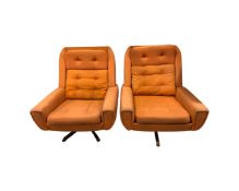 A pair of 1970's Danish swivel armchairs in orange buttoned fabric