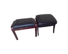 A pair of stained beech framed footstools in black leather