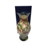 A Moorcroft vase decorated with lilies, boxed.