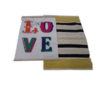 An Erica Davis woolen rug together with a fabric wall hanging 'Love'