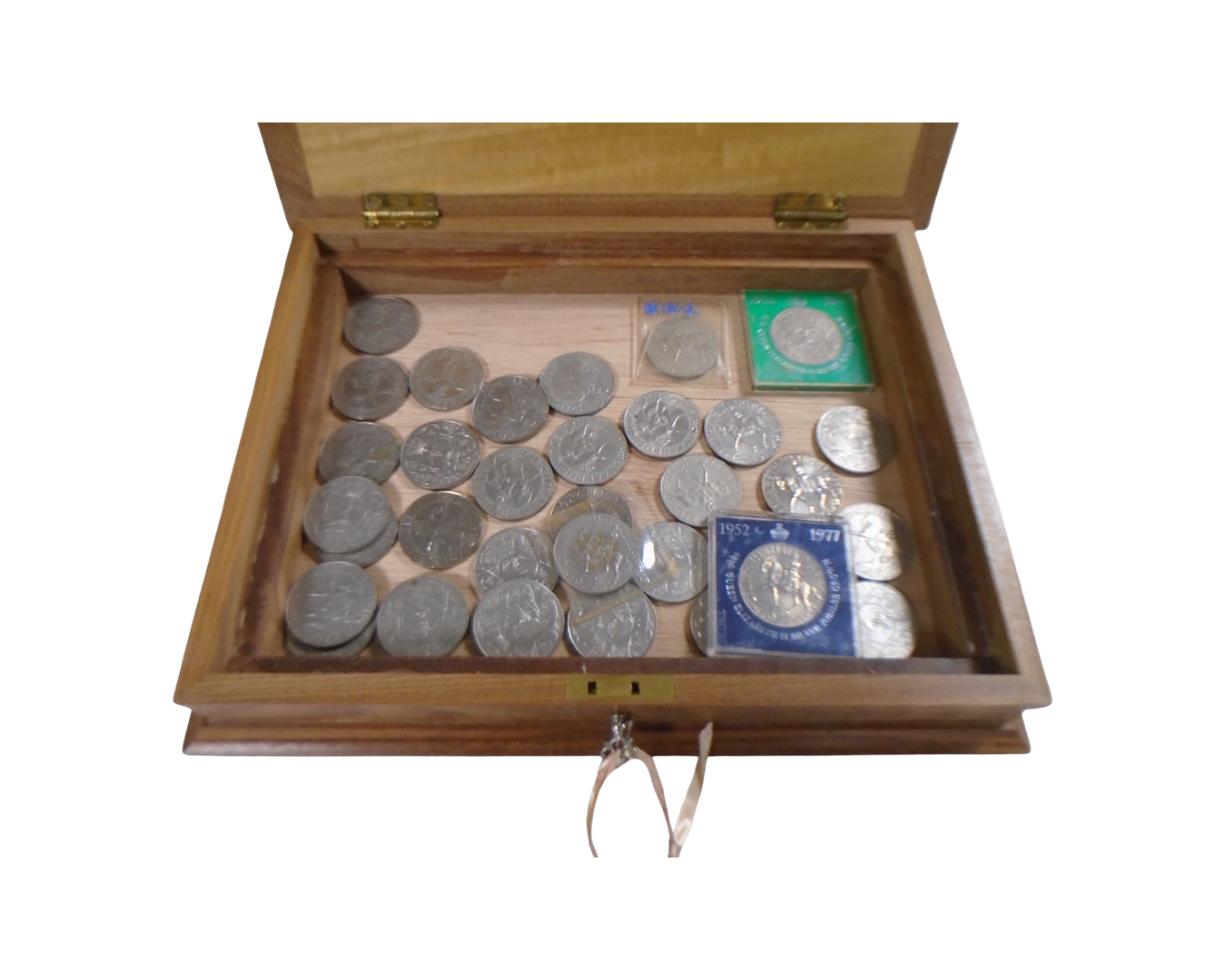 A wooden table box containing a quantity of Queen Elizabeth II Silver Jubilee crowns.