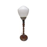 An oak barley twist table lamp with opaque glass shade.