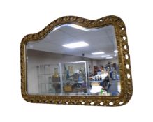 An ornate gilt framed arch topped bevelled mirror.