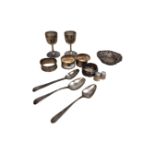 A collection of silver items to include heart shaped pin dish, four napkin rings, two thimbles,