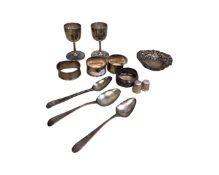 A collection of silver items to include heart shaped pin dish, four napkin rings, two thimbles,