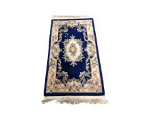 A Chinese embossed fringed rug on blue ground,