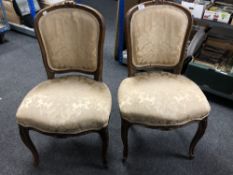 A pair of French carved beech framed salon chairs in golden floral fabric