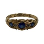 An 18ct yellow gold ring set with three synthetic sapphires, size M, 2.1g.