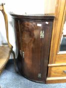 A George III mahogany bow fronted double door corner cabinet,