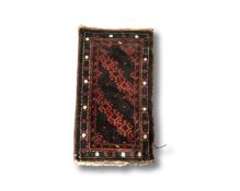 An Afghan rug on red and black ground,