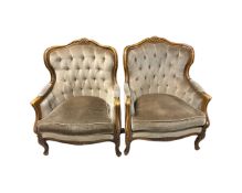 A pair of carved beech framed salon armchairs in brown buttoned dralon