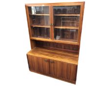 A mid-20th century double door glazed bookcase with cupboards fitted below in a rosewood finish.