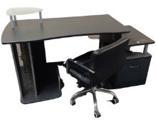 A contemporary black computer desk with black leather swivel chair and filing cabinet