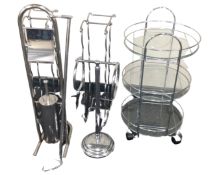 A glass and metal three tier bathroom trolley together with further chrome stands and bathroom