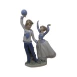 A Lladro figure of children playing with a ball.